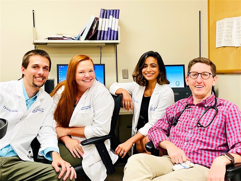 A group of four smiling hematology-oncology fellows.